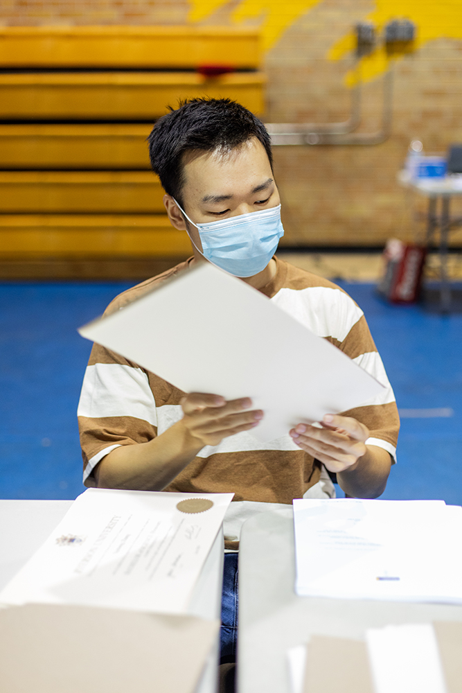 A volunteer organizing a graduation certificate package