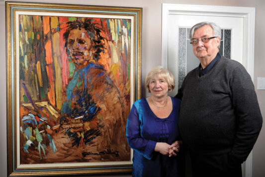 Rudy Bies and wife Gloria in front of a painting