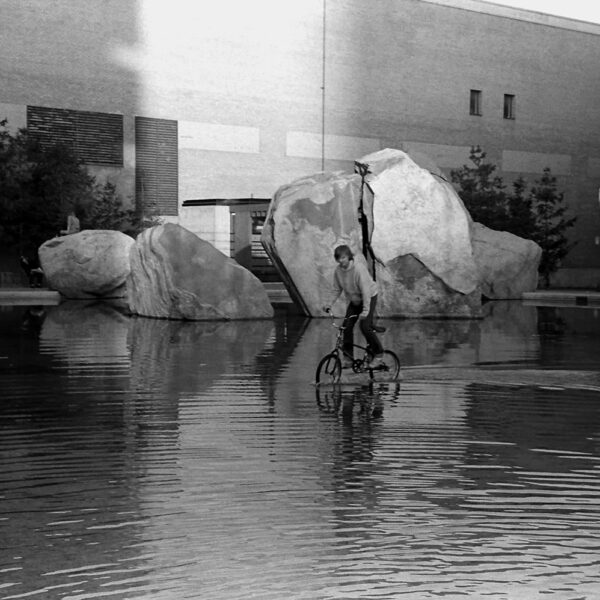 A young man rides a bicycle through Lake Devo in 1982