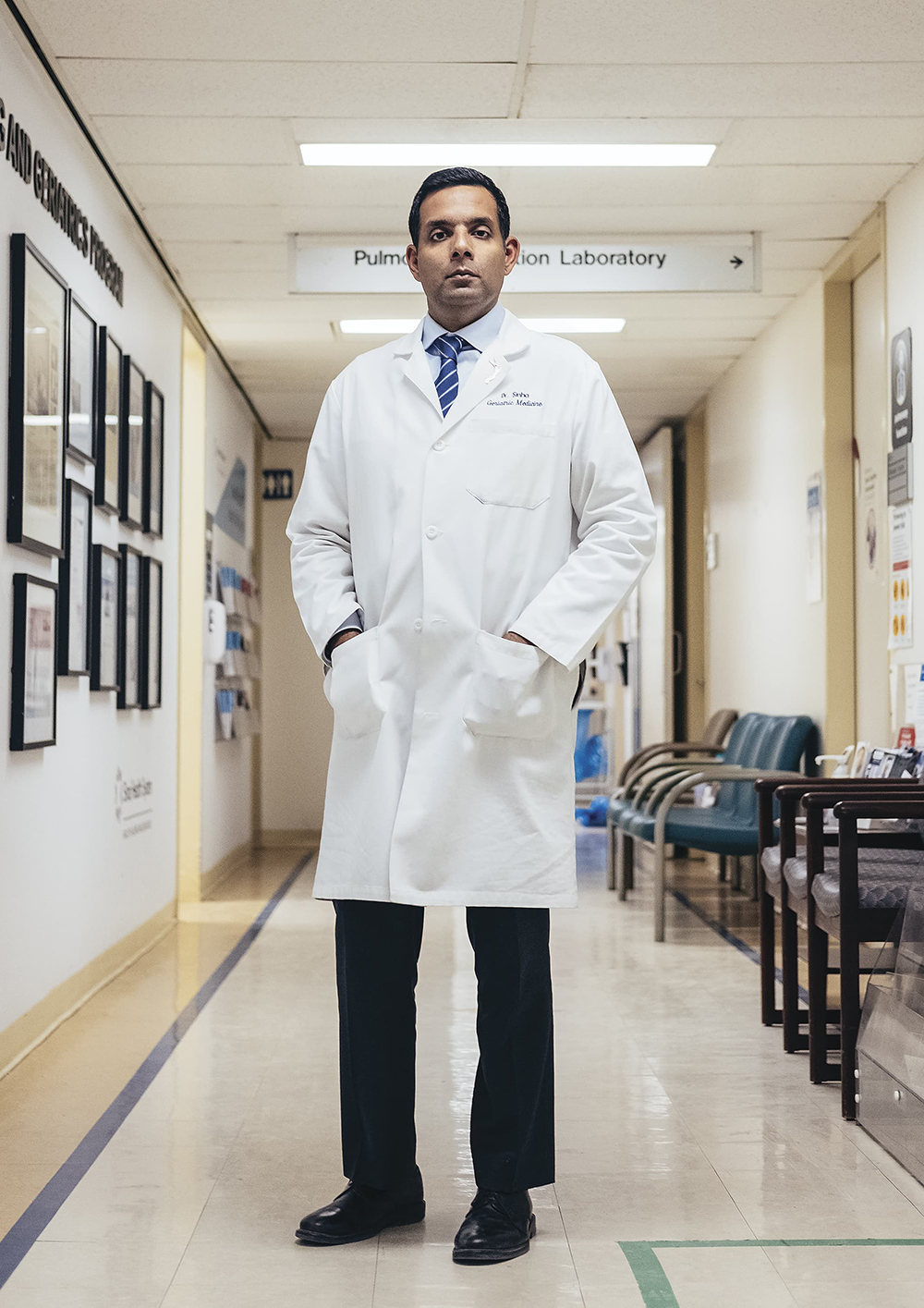 Dr. Samir Sinha stands wearing a white lab coat in the hospital hallway
