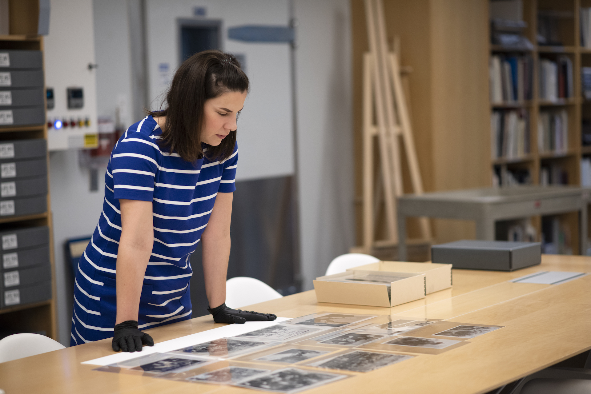 Carla Jean Stokes looking over several images laid out on a table.