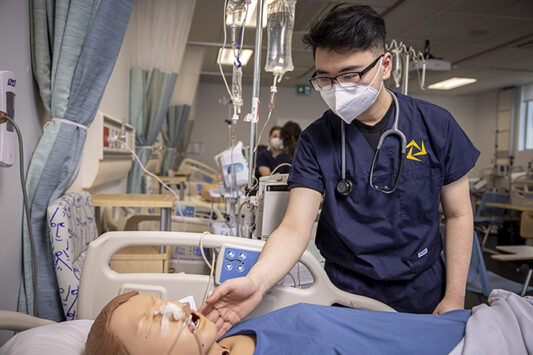 A nursing student practises on a mannequin