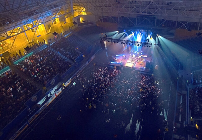 Looking down onto a crowd of people enjoying a concert inside the Mattamy Athletic Centre.