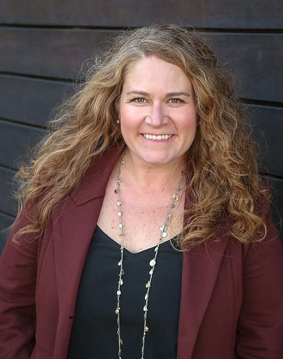 Courtney Cassidy Vint wearing a dark red blazer.