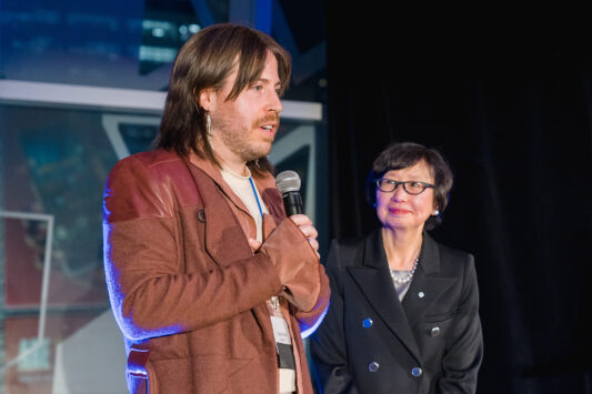 Curtis Oland talks into a mic.