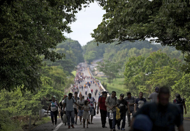 Migrants walking along the road.