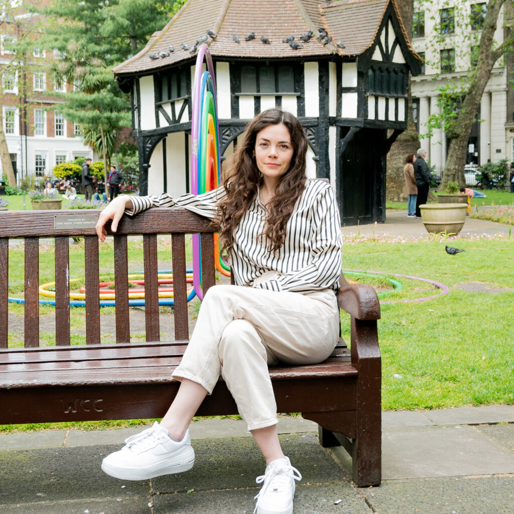 Haley McGee sitting on a bench outside.