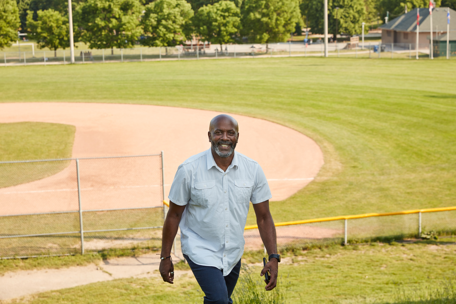 Marlon Merraro standing outside by a baseball diamond.