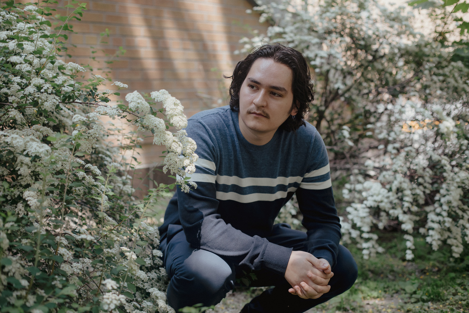 Luke Galati standing outside near flowers.