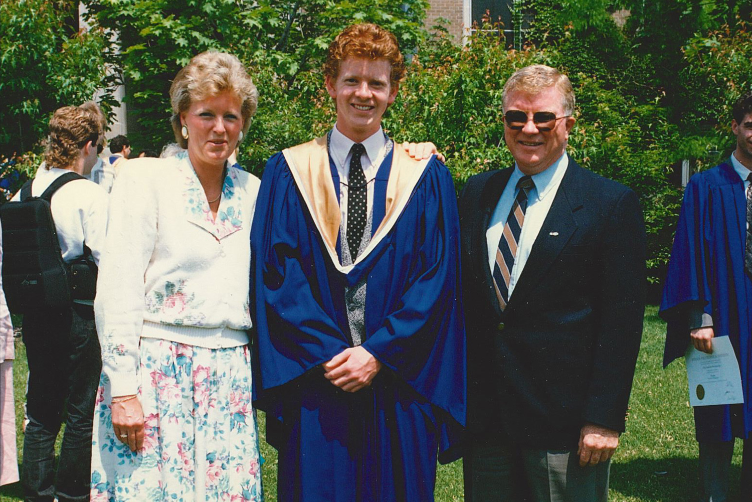 amie at Convocation with his parents on either side of him.