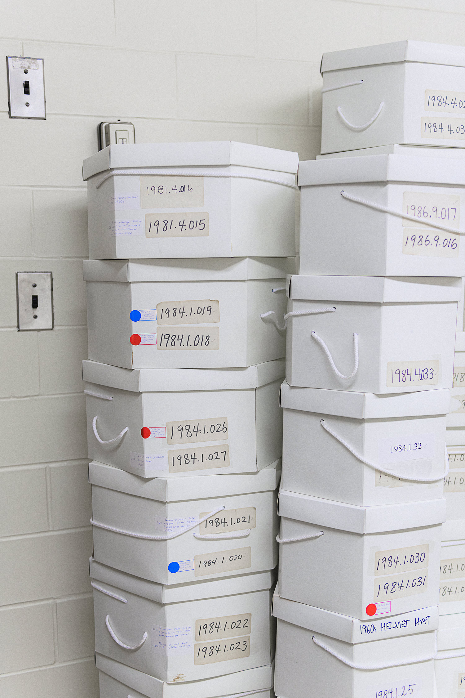 Hexagon shaped white hat boxes stacked on top of one another.