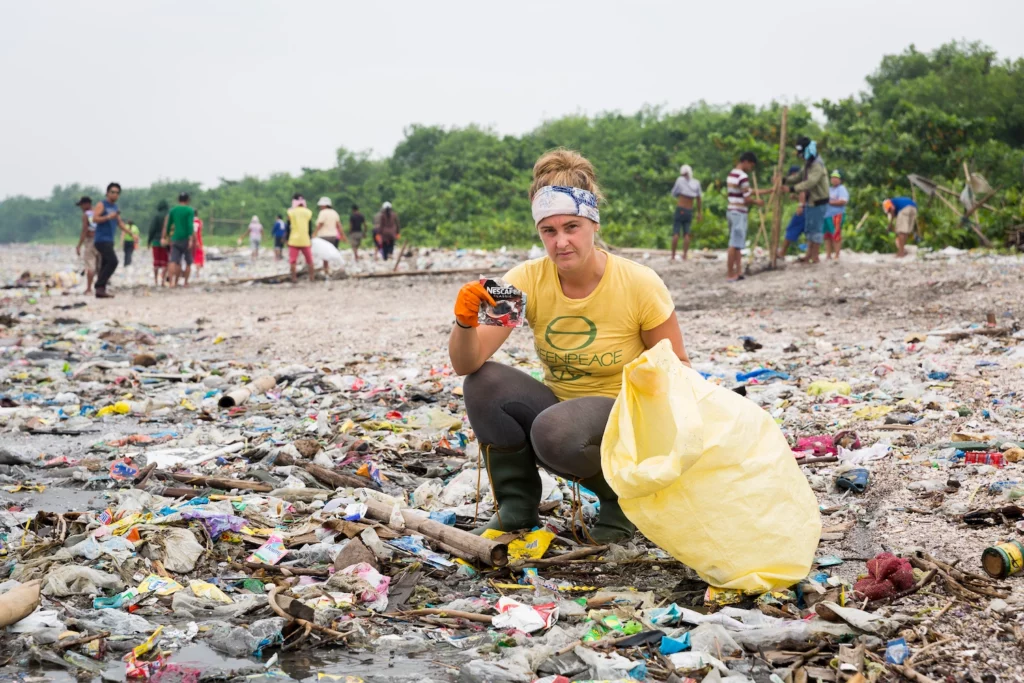 Sarah King cleaning up plastics on a beach.