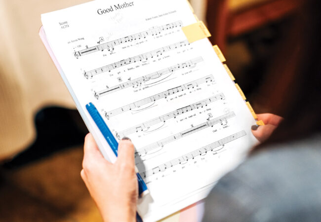 A person holding sheet music.