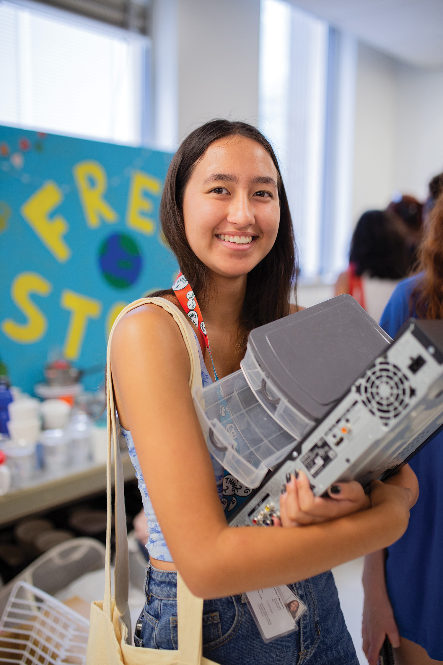 A student holds on to items obtained at the free store including a plastic organizer.