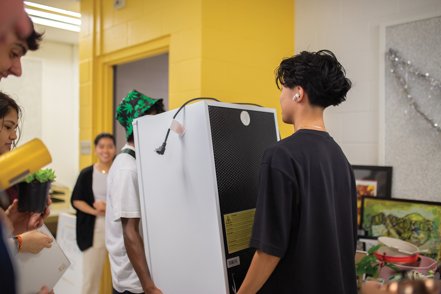 Two students carry a small appliance obtained at the free store.