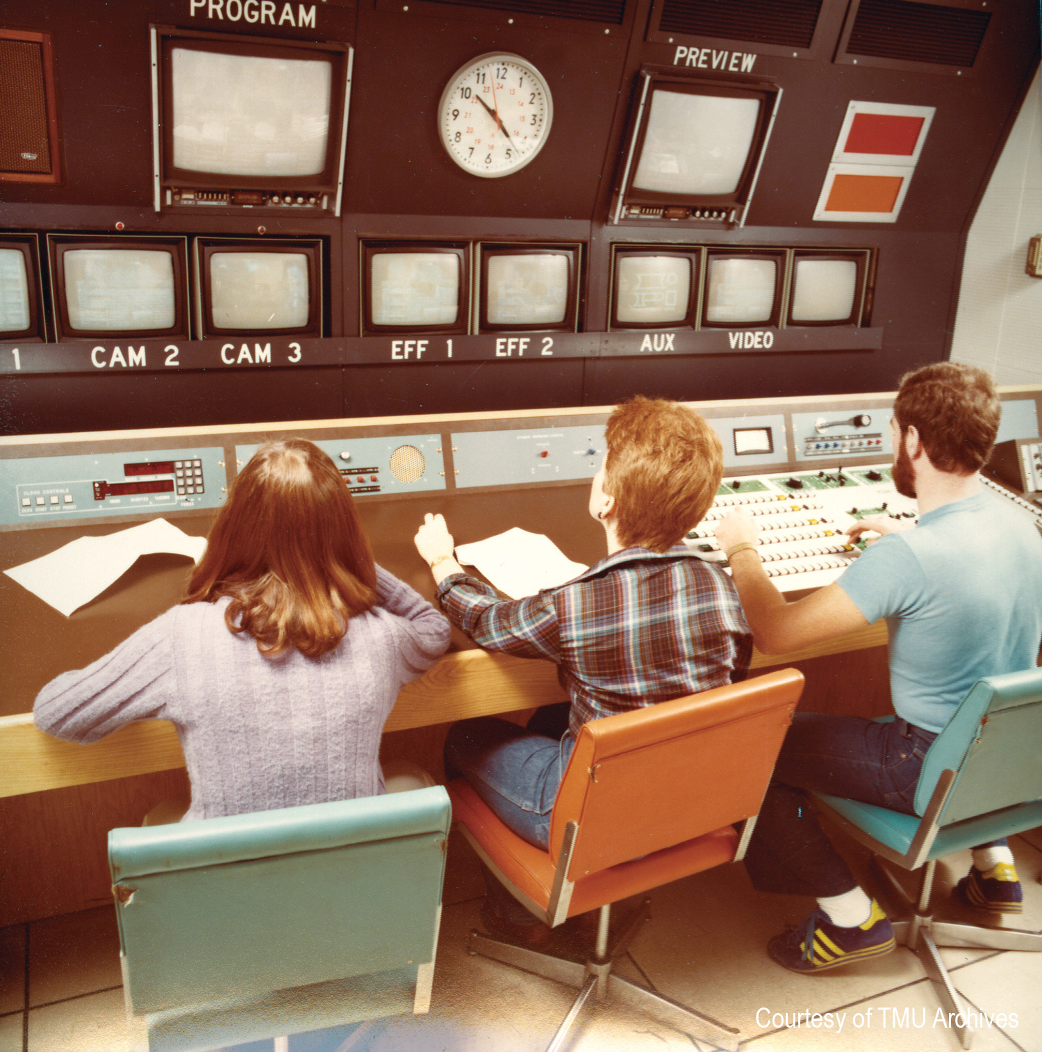 Three university students sit in a 1970s television control room.