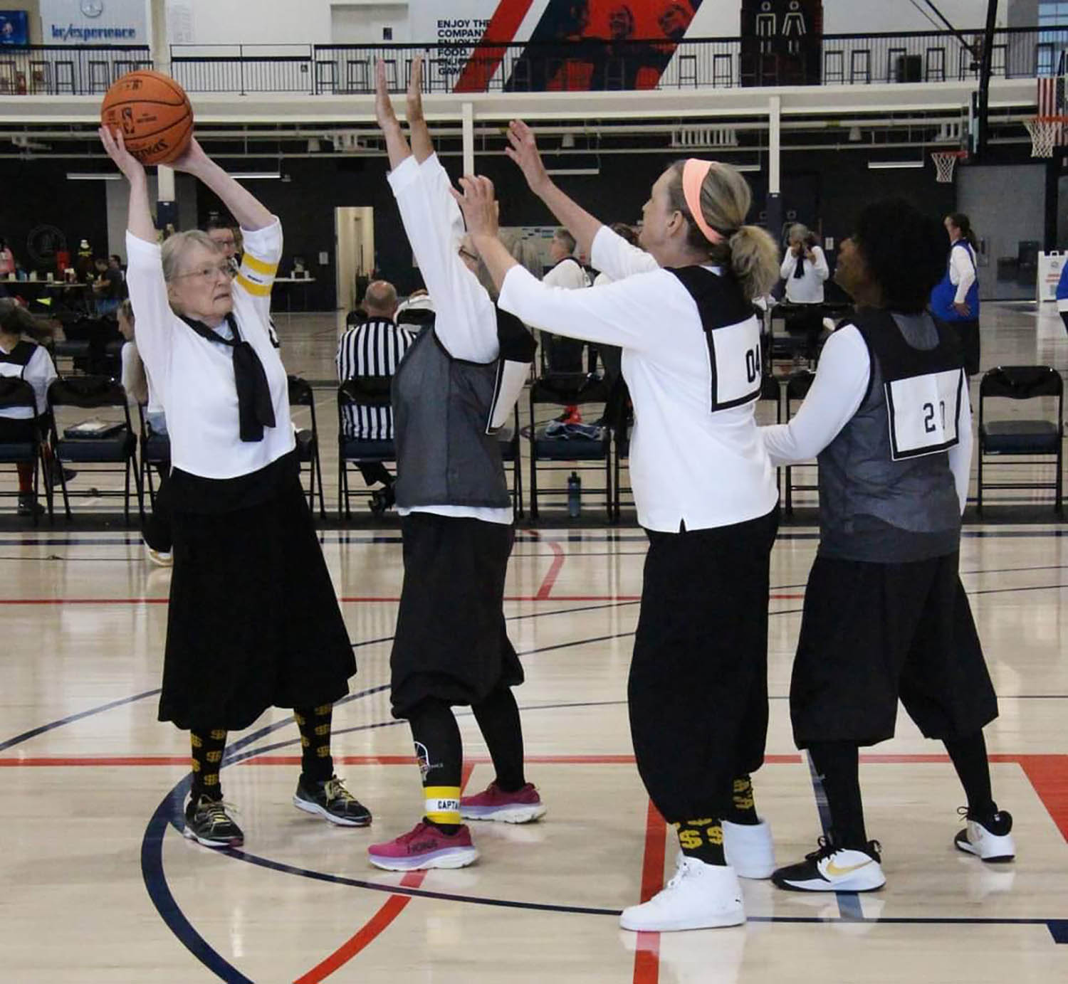 Women playing basketball together.