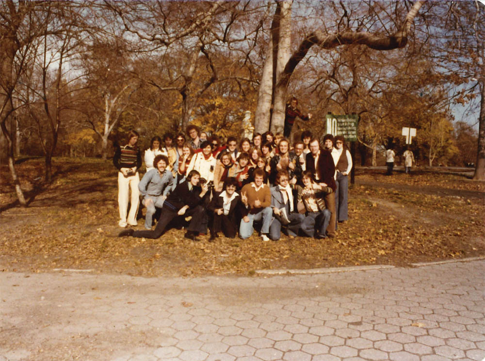 A group of people pose for a photo in a park.