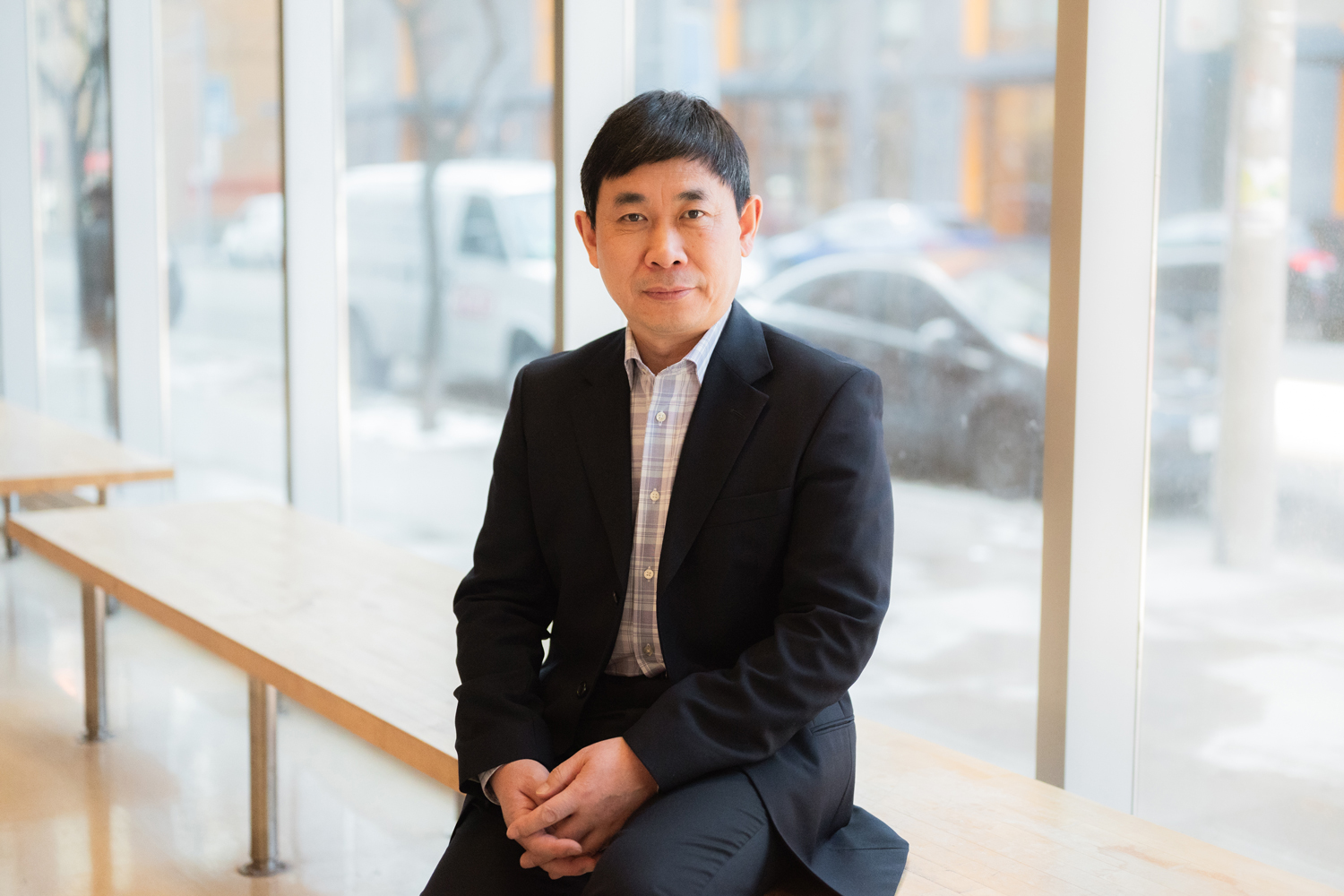 Richard Wang poses for a photo near a window.