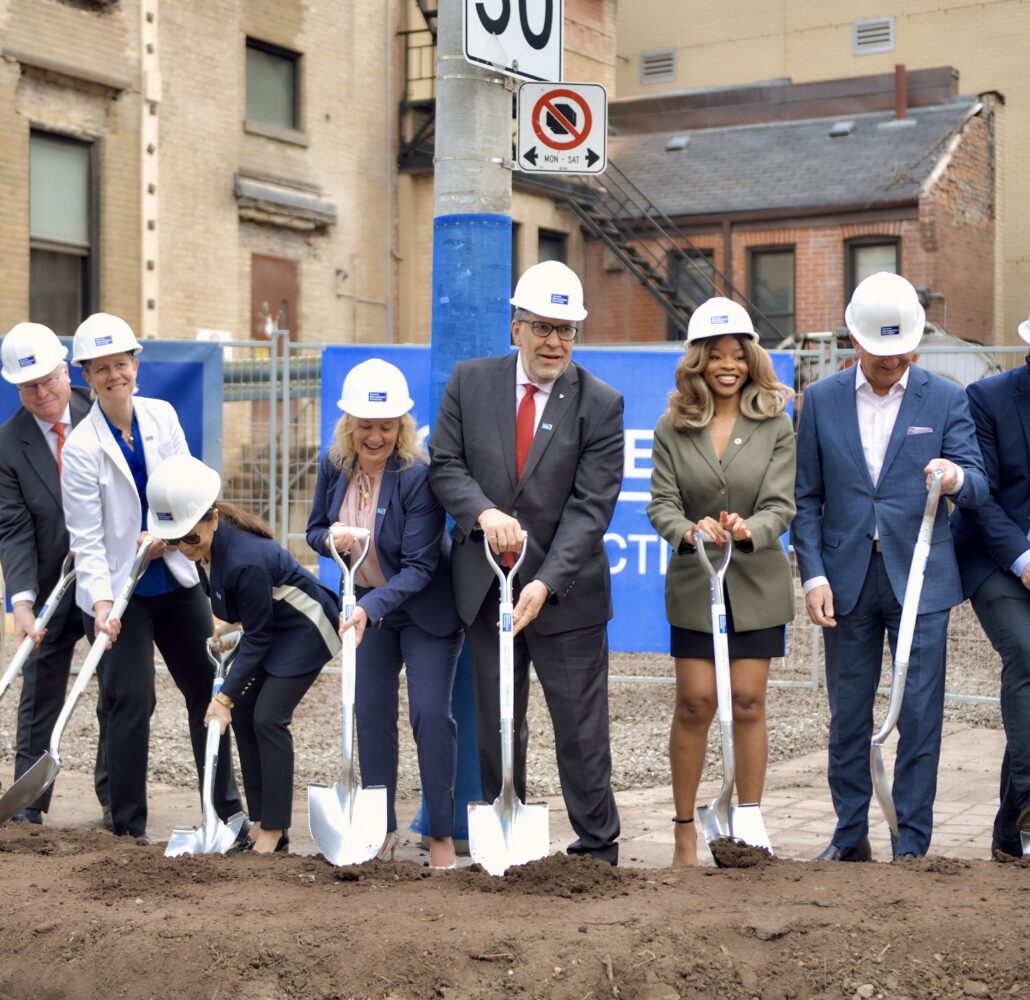 TMU community members dig their shovels into the ground at the groundbreaking event for the Student Wellbeing Centre.