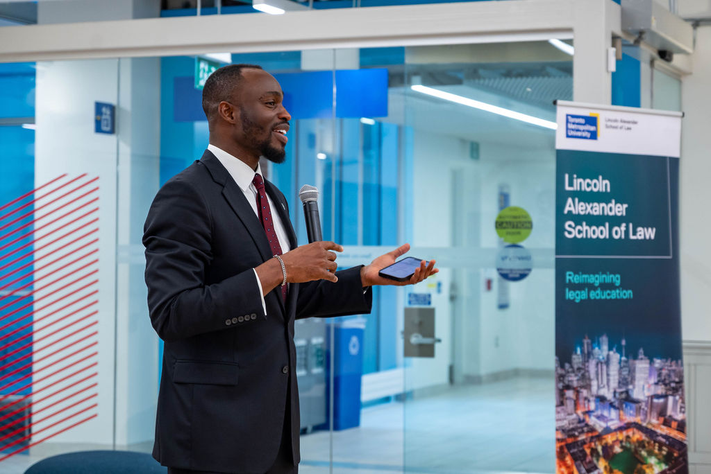 Jake Effoduh standing with a mic, giving a talk.