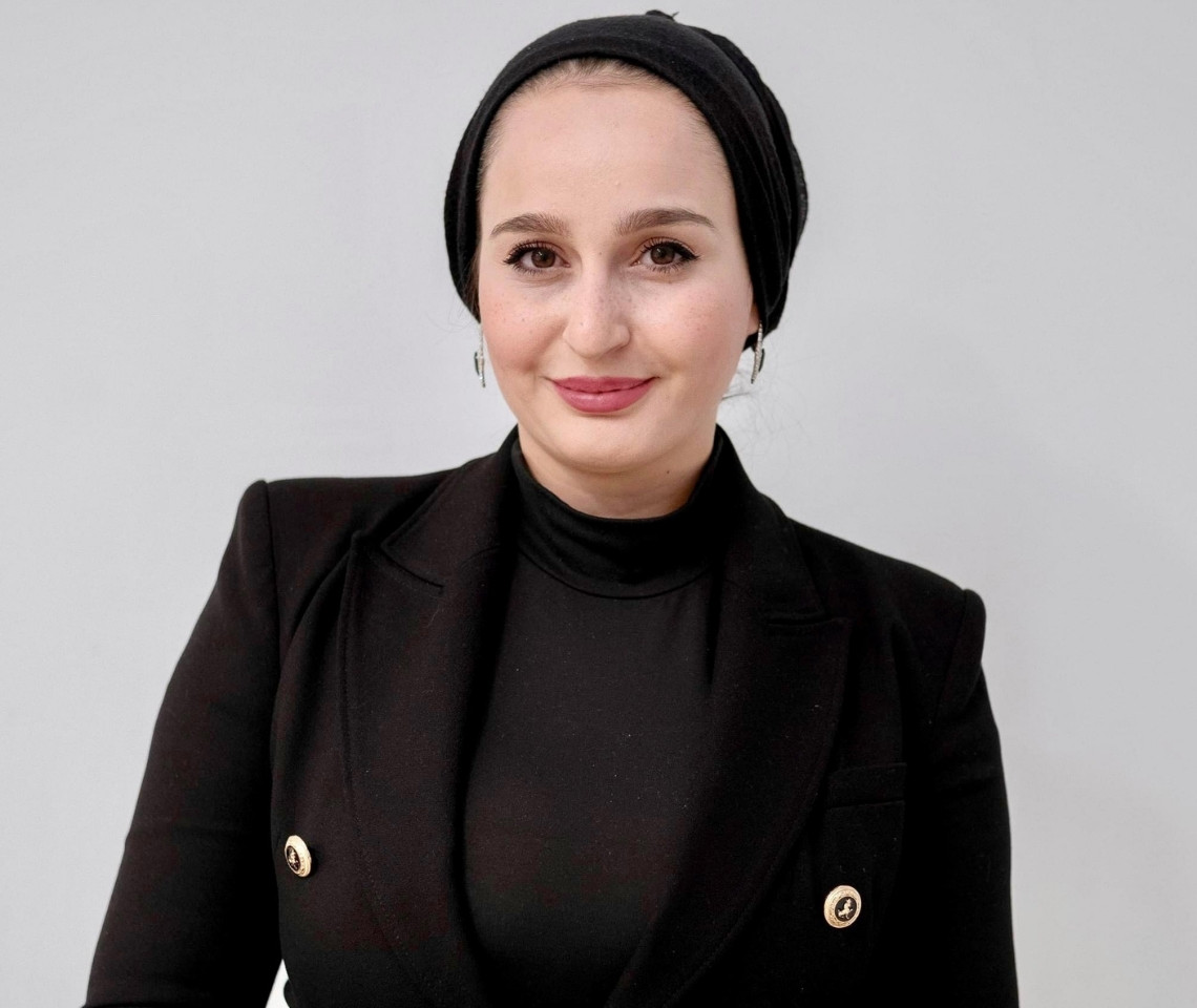 A headshot of Hanen Nanaa wearing black.