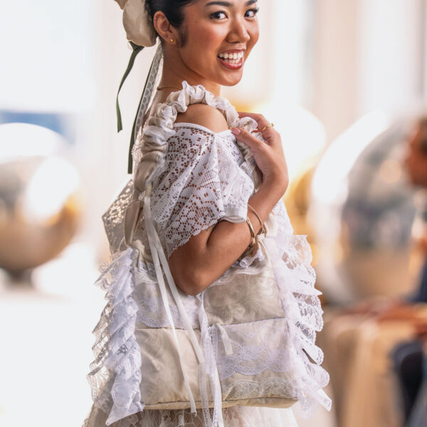 A model wears a pale textured runway look and carries one of Tristanne Lovetana’s sculptural pillow purses at New York Fashion Week.