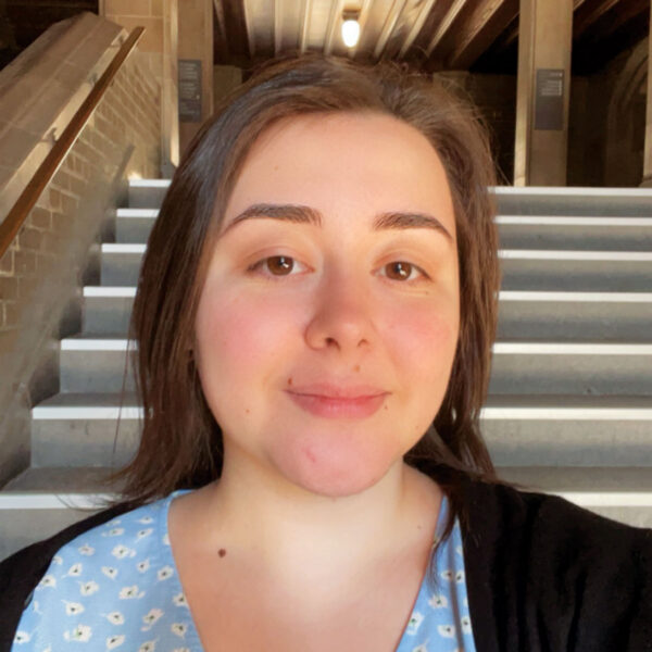 Marienza Miserere takes a selfie indoors, wearing a light blue patterned top and black cardigan.
