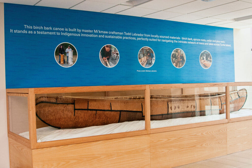 A canoe housed within a display case.