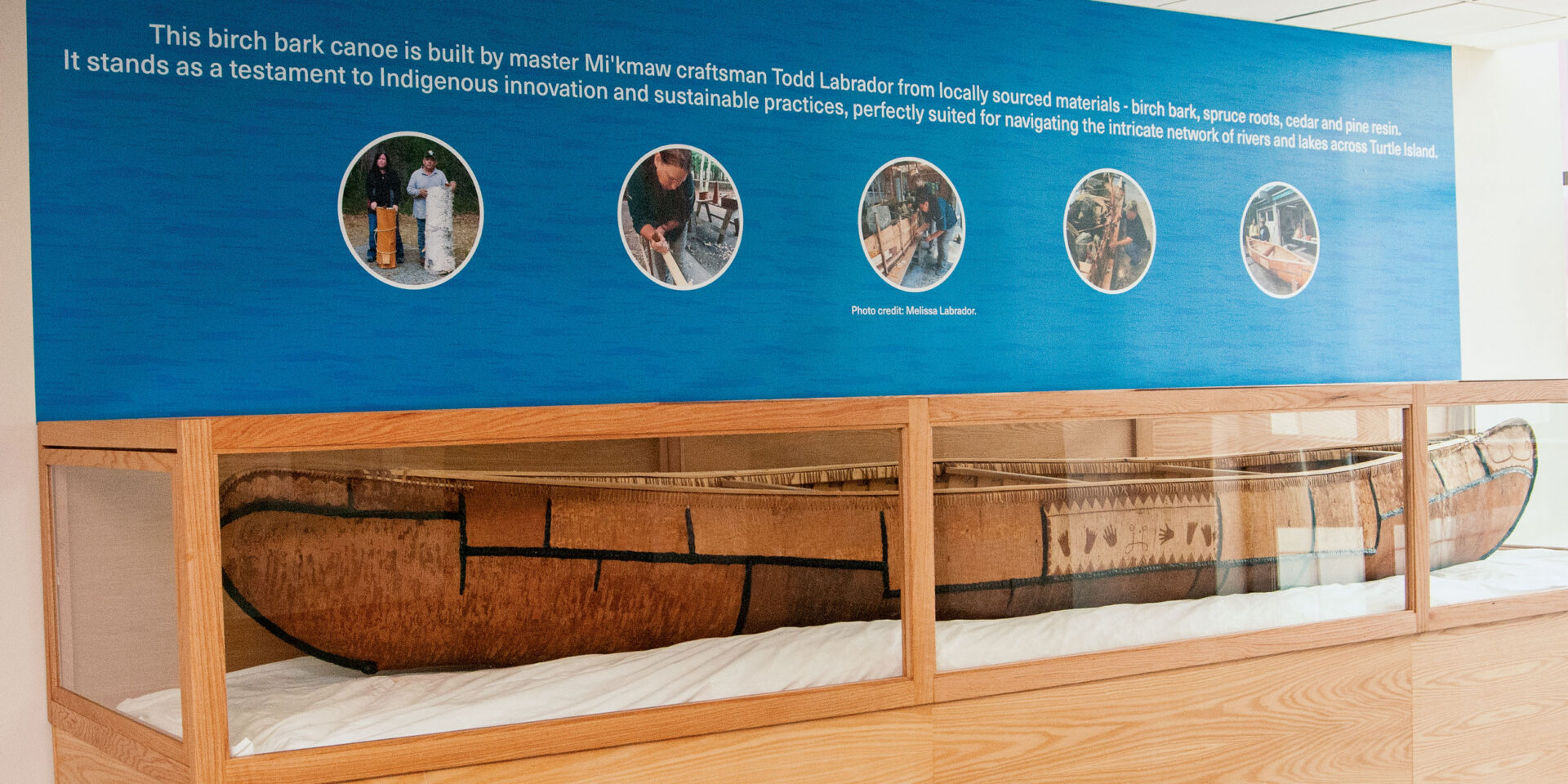A canoe housed within a display case.