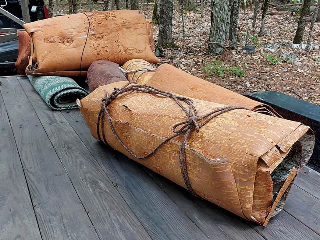 Birch bark rolled up and sitting on a deck outside.
